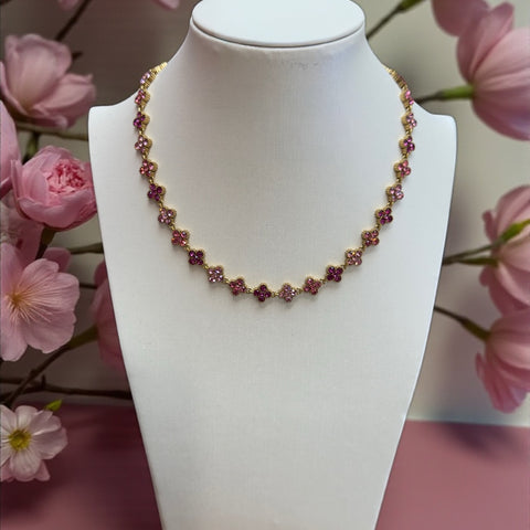 Collier Rosée fleurie rose sur un buste blanc entouré de fleurs