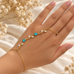 Bijou de main Jardin d’Éclat doré, turquoise, porté sur une main