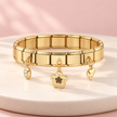 Bracelet Bella doré extensible – Fleur & cœur sur support ivoire