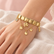 Bracelet Bella doré extensible, modèle Trèfles et cœurs porté au poignet