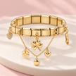 Bracelet Bella doré extensible – Trèfles & cœurs sur support ivoire