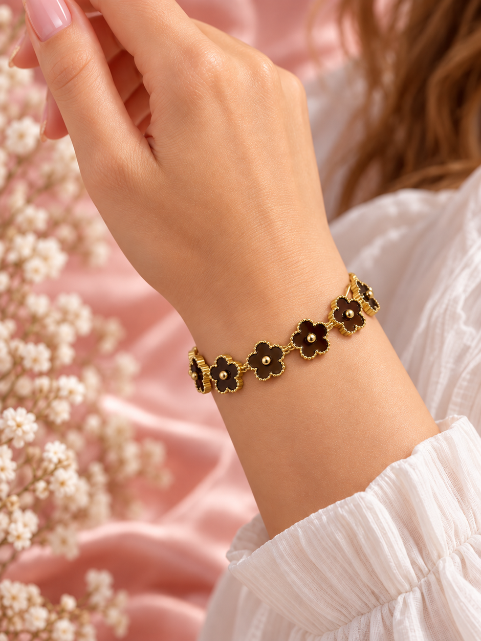 Bracelet Fleur doré à motifs floraux marron, porté au poignet sur fond rose poudré – Secret de Rose bijoux