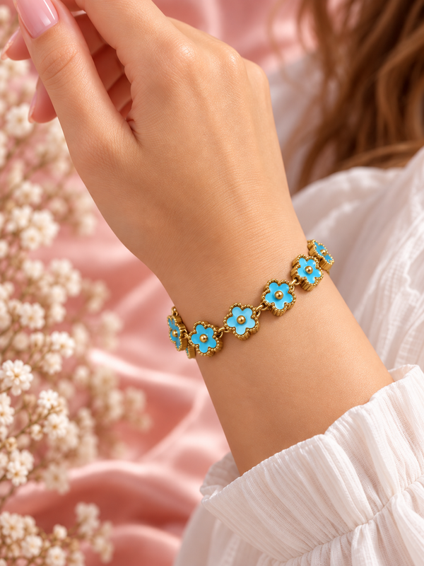 Bracelet Fleur doré à motifs floraux turquoise, porté au poignet sur fond rose poudré – Secret de Rose bijoux