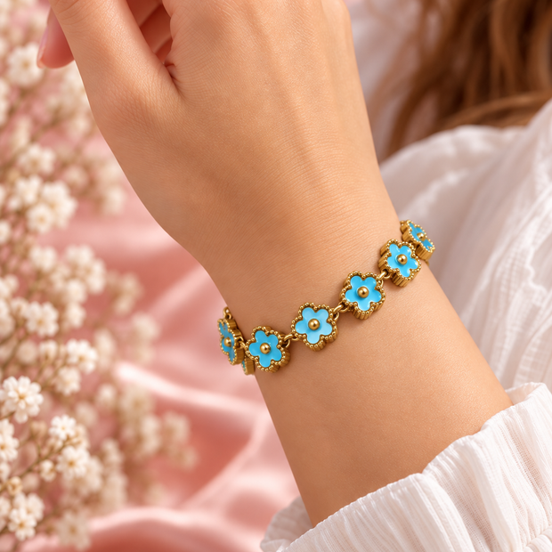 Bracelet Fleur doré à motifs floraux turquoise, porté au poignet sur fond rose poudré – Secret de Rose bijoux