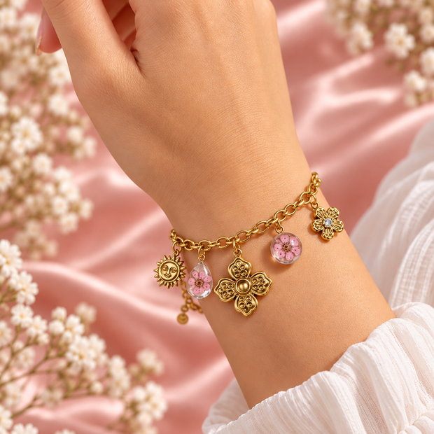 Bracelet Flora doré à fleurs roses porté au poignet sur fond rose poudré – Secret de Rose bijoux