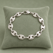 Bracelet grain de café argenté, maille L, sur présentoir vert sauge