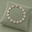Bracelet grain de café argenté, maille S, sur présentoir vert sauge