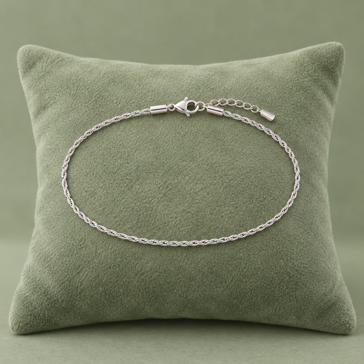 Bracelet maille tressée argenté modèle 0,4, 15 + 5 cm sur coussin vert sauge