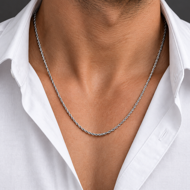 Chaîne torsadée fine 0,4 argentée portée par un homme en chemise blanche