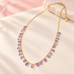Collier Éclats de couleur violet, chaîne dorée et pampilles facettées lilas sur fond ivoire