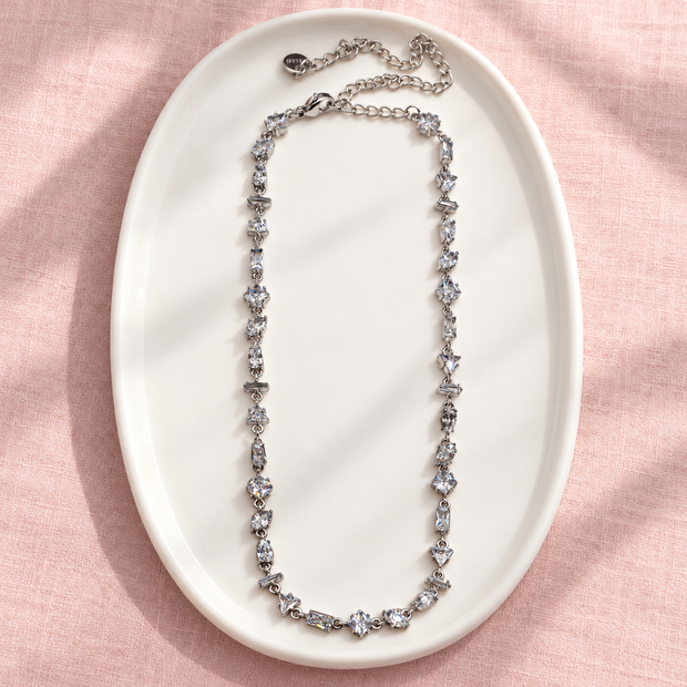 Collier Prisme en acier et strass – Argenté – Transparent sur support blanc et fond rose