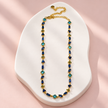 Collier Prisme en acier et strass – Doré – Bleu sur support blanc et fond rose