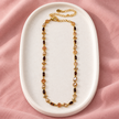 Collier Prisme en acier et strass – Doré – Champagne sur support blanc et fond rose