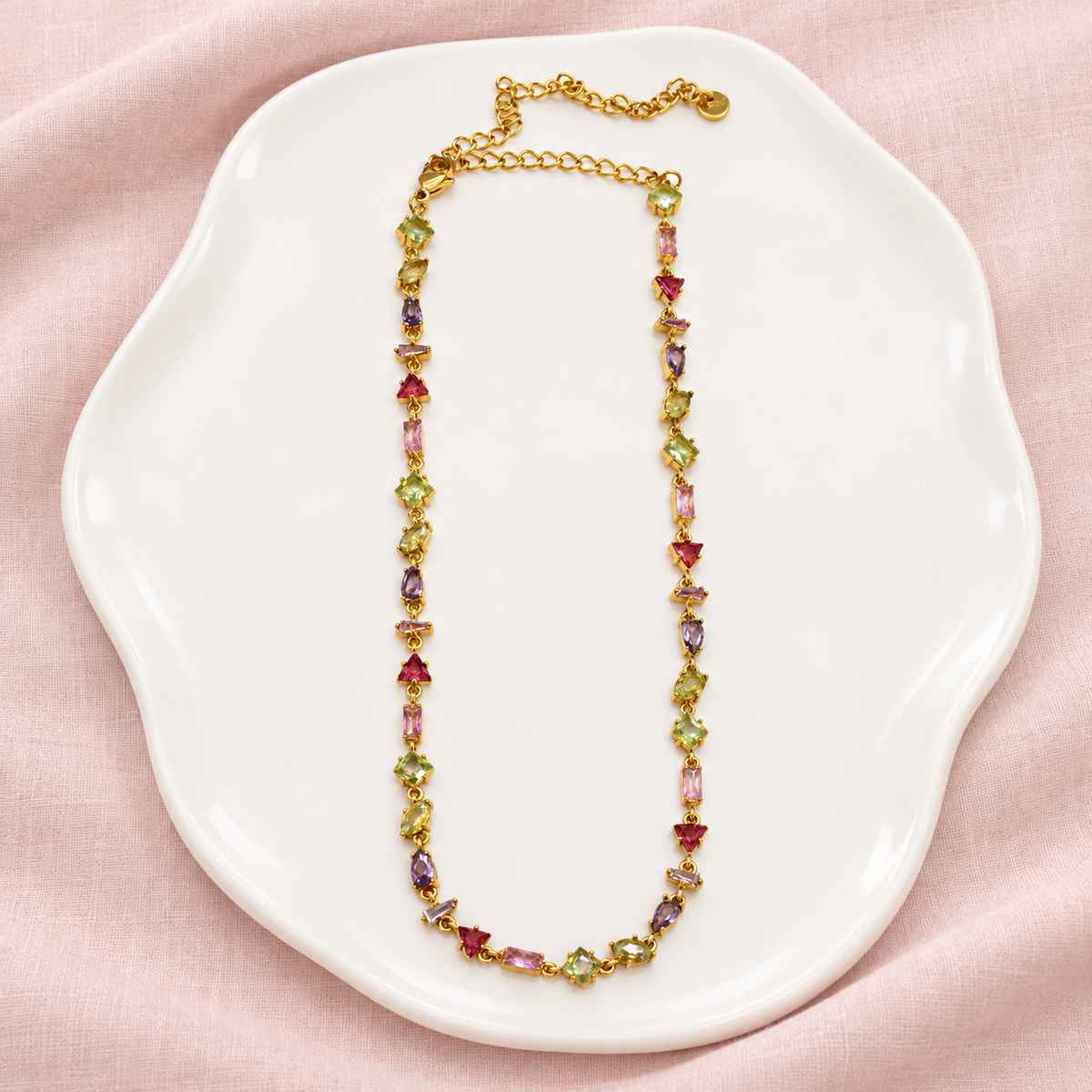 Collier Prisme en acier et strass – Doré – Multicolore sur support blanc et fond rose