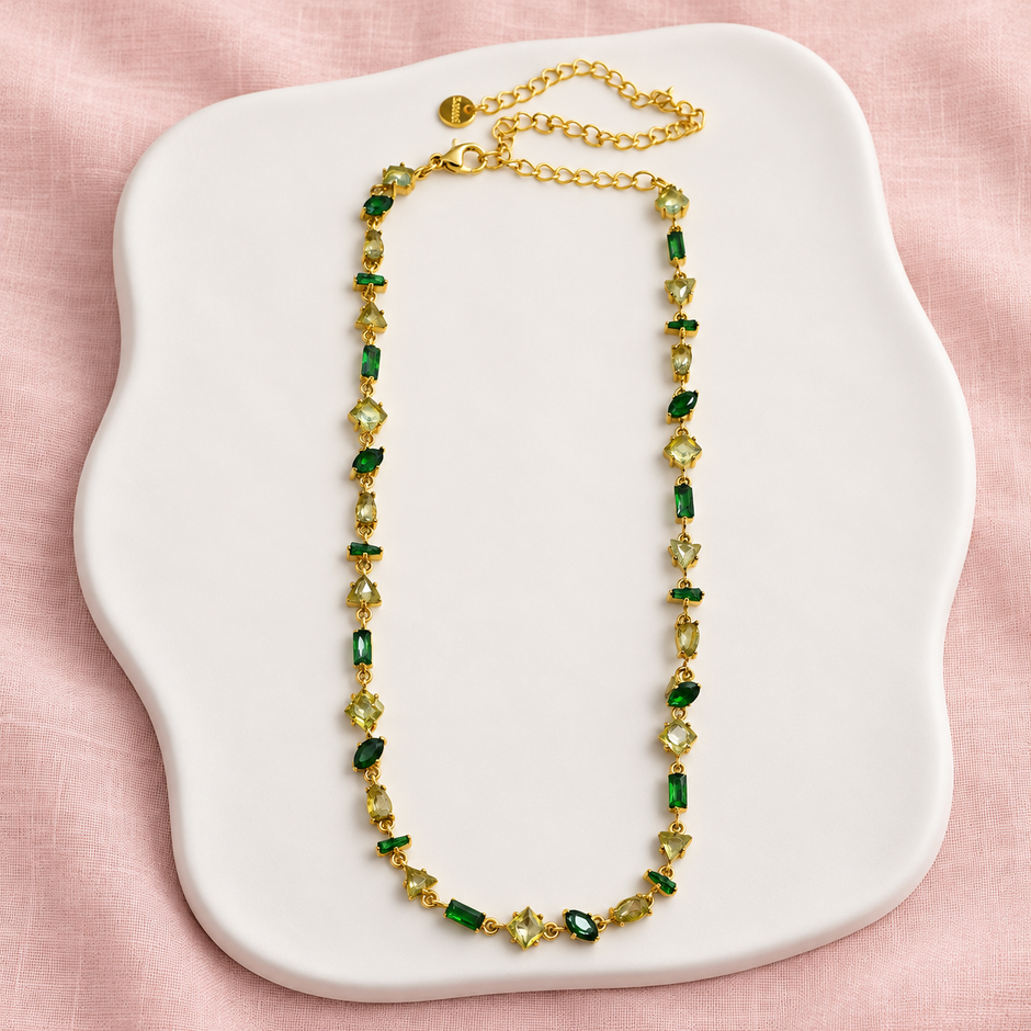 Collier Prisme en acier et strass – Doré – Vert sur support blanc et fond rose