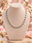 Collier Rosée fleurie argenté sur présentoir ivoire, fleurs scintillantes