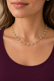 Collier Rosée fleurie doré à trèfles arrondis porté avec un haut prune