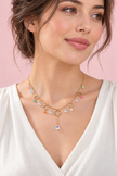 Collier Y Trèfles pastel doré porté, cinq trèfles ajourés et pampilles colorées