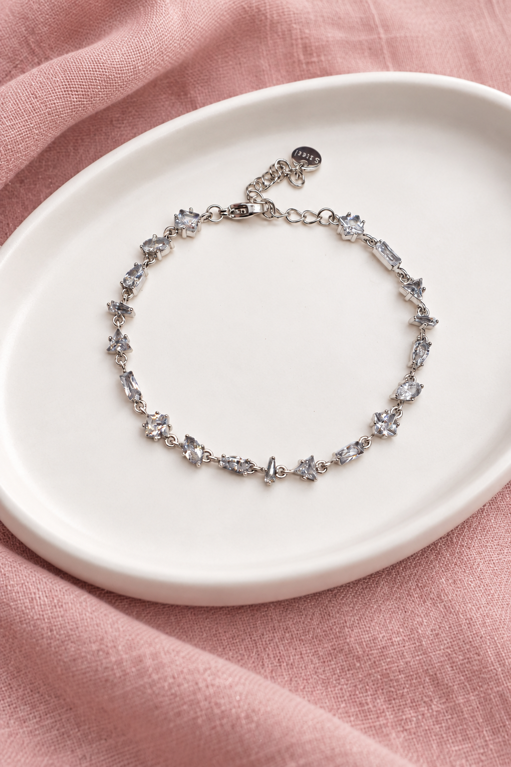 Gourmette Prisme en acier inoxydable et strass – Argenté – Transparent sur support blanc et fond rose