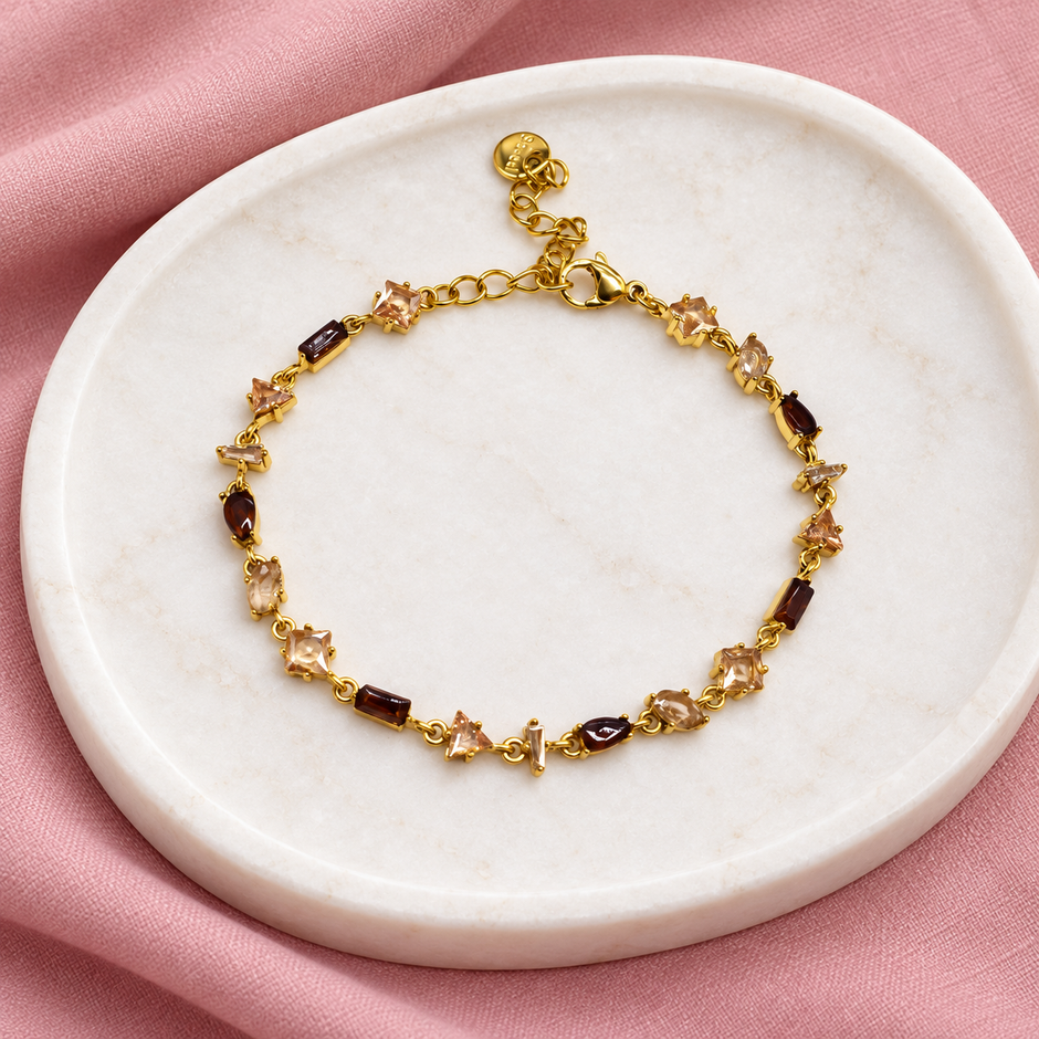 Gourmette Prisme en acier inoxydable et strass – Doré – Champagne sur support blanc et fond rose