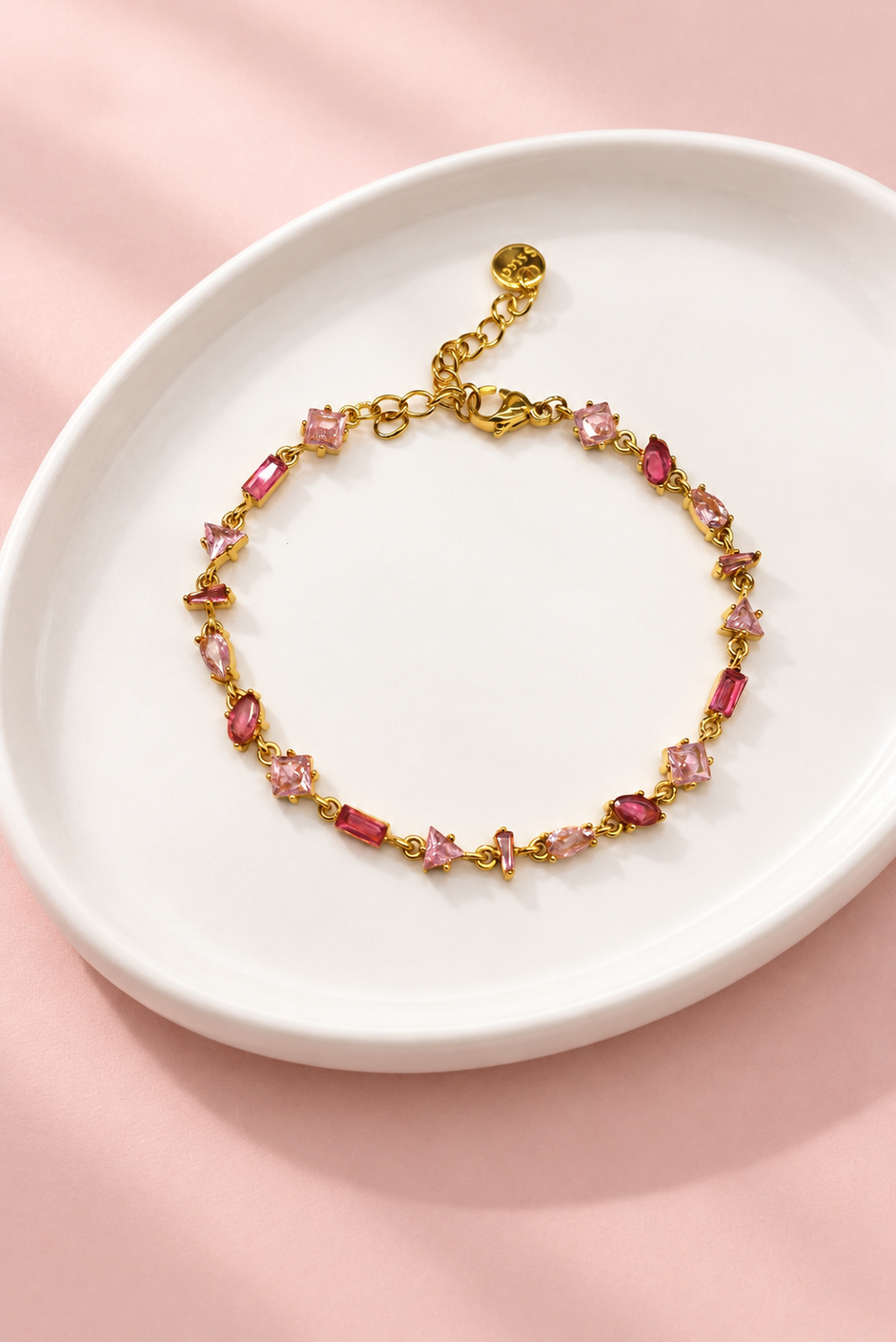 Gourmette Prisme en acier inoxydable et strass – Doré – Rose sur support blanc et fond rose