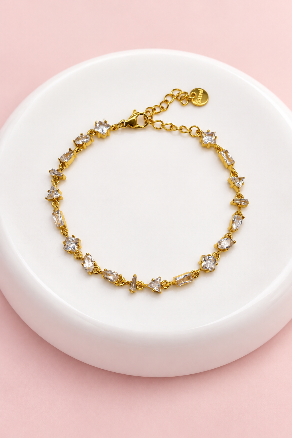 Gourmette Prisme en acier inoxydable et strass – Doré – Transparent sur support blanc et fond rose