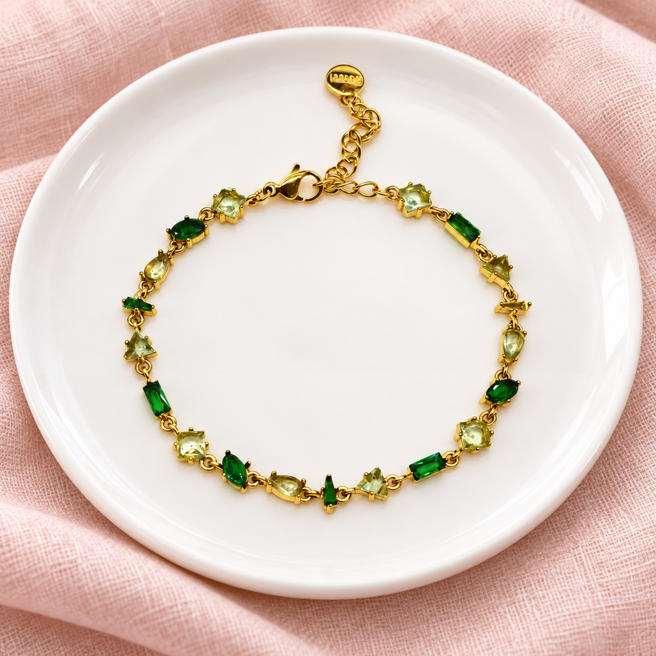 Gourmette Prisme en acier inoxydable et strass – Doré – Vert sur support blanc et fond rose